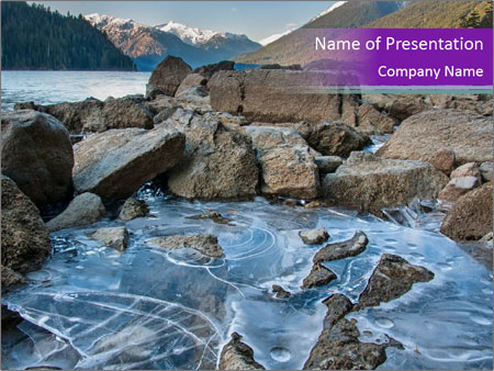 Cheakamus Lake Shoreline Featuring Icy Formations And Mountainous Backdrop. Google Slides Theme